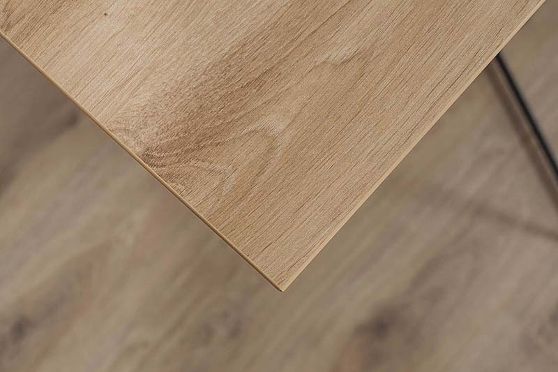 Detailaufnahme einer Holzplatte mit natürlicher Maserung und abgeschrägter Kante. Der warme Holzton und die feine Struktur der Oberfläche heben die Qualität und Handwerkskunst hervor.